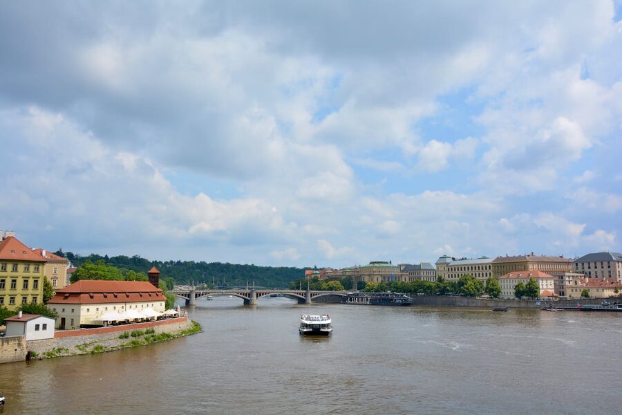 Passenger cruise ship on the Vltava with Pragues old riverside in the background