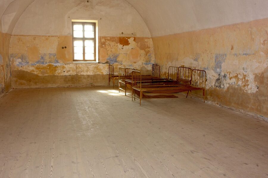 Rusted iron-frame dormitory beds inside Terezin