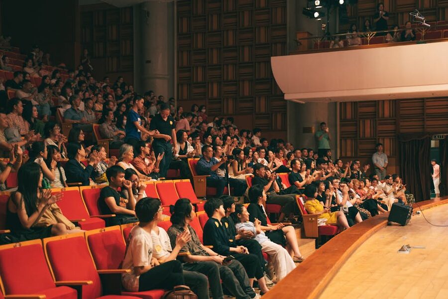 Lively audience applauding inside a spacious classical concert hall