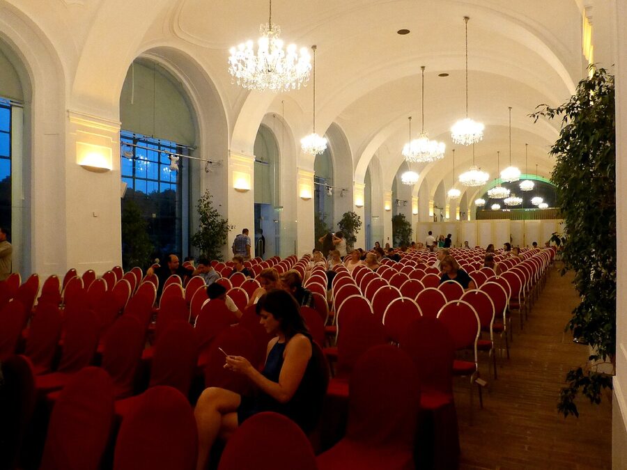 Concert at Schonbrunn Orangery with seated audience and lit chandeliers