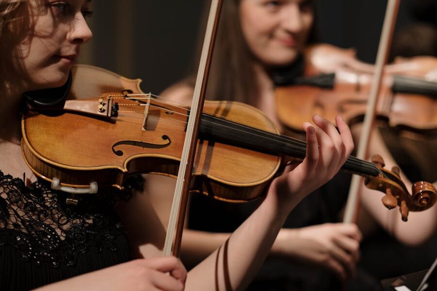 Two classical violin musicians performing a piece together
