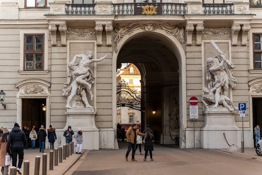 People walking through a Hofburg archway in Vienna's old town