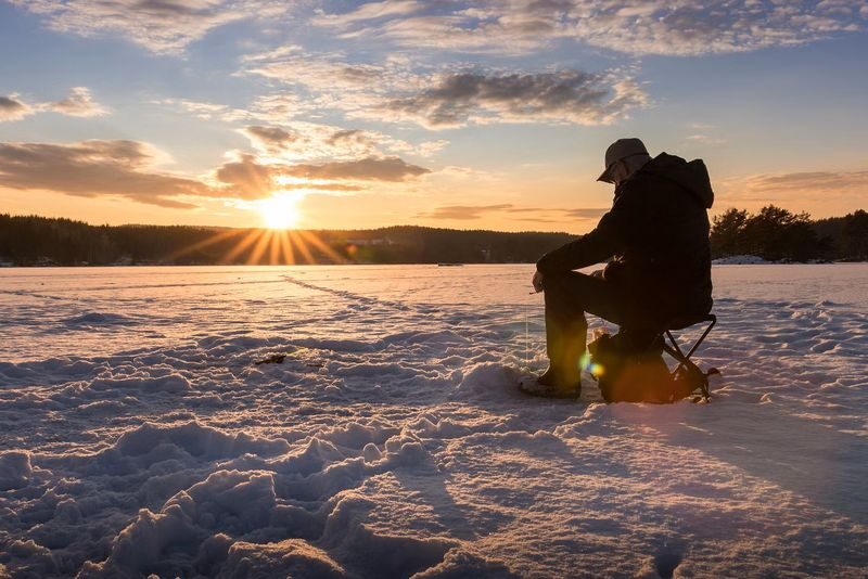 Ice Fishing Lapland Experience from Rovaniemi - Drilling through the ice and waiting for a bite