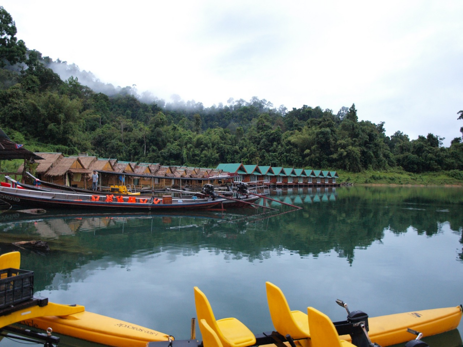 An image capturing the breathtaking beauty of Khao Sok Lake's crystal-clear waters surrounded by lush greenery